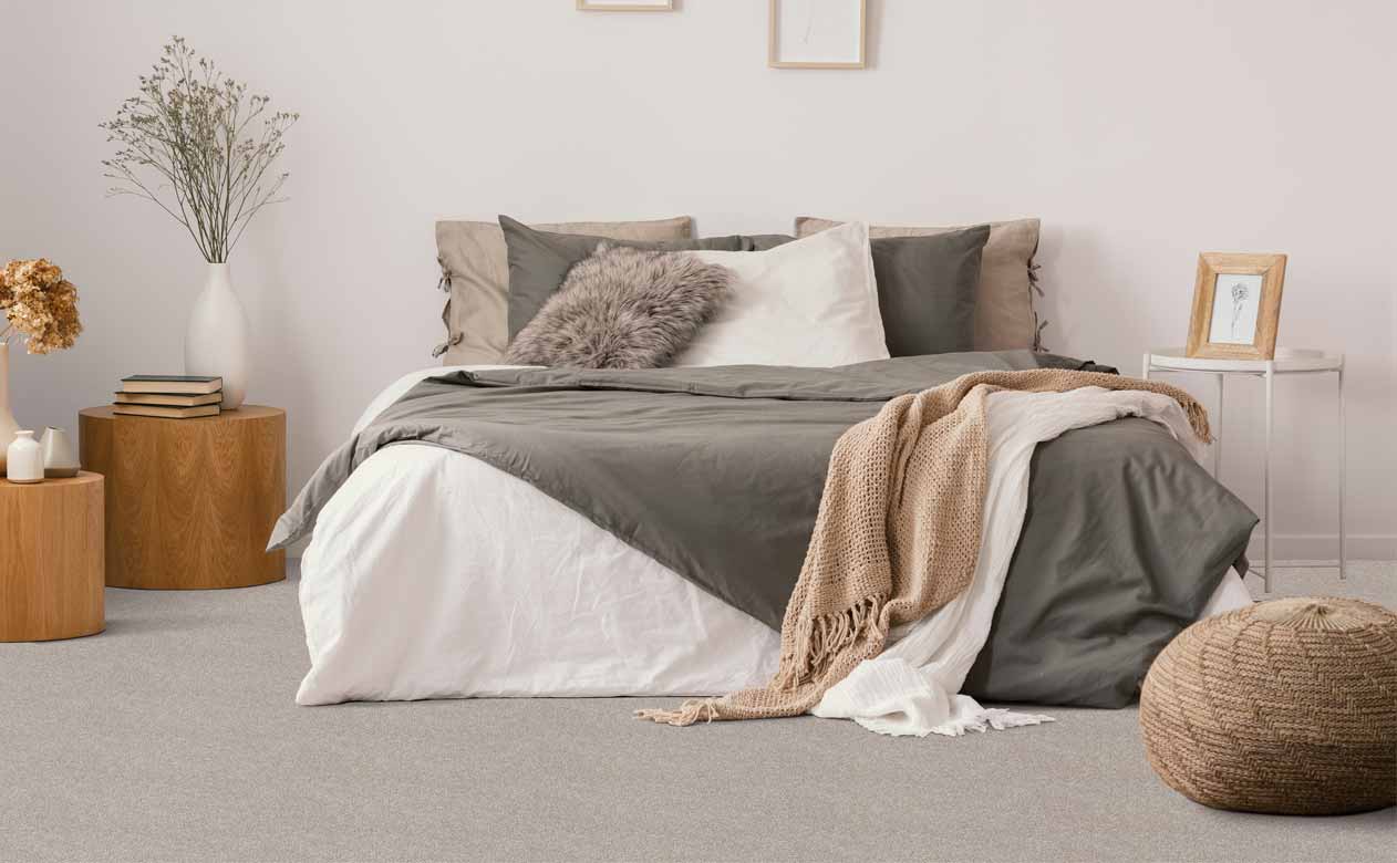 bedroom with soft grey and cream furniture and carpet.