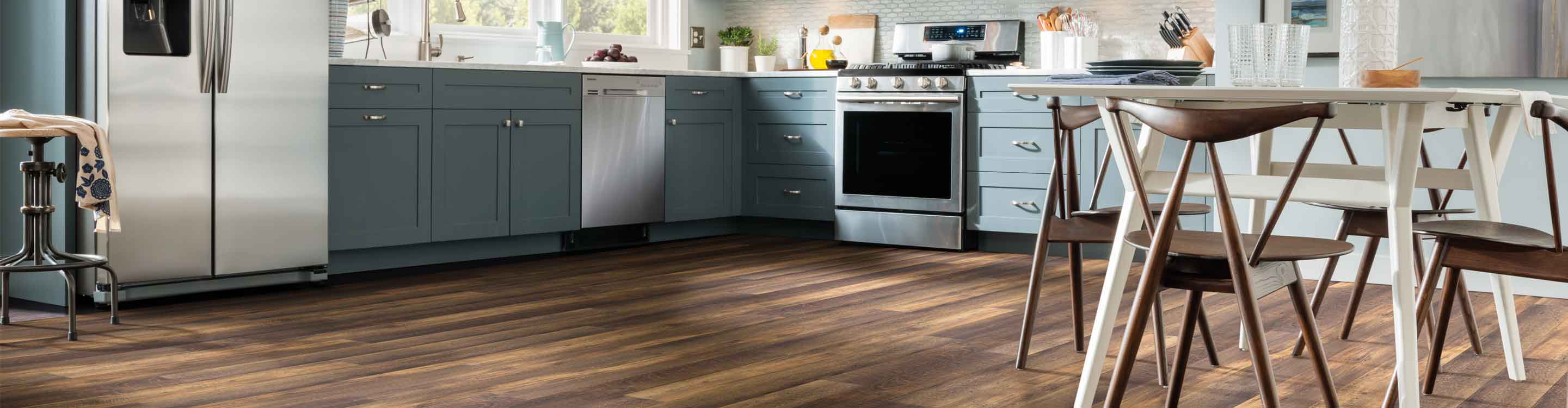luxury vinyl flooring in a kitchen and breakfast nook with blue cabinetry